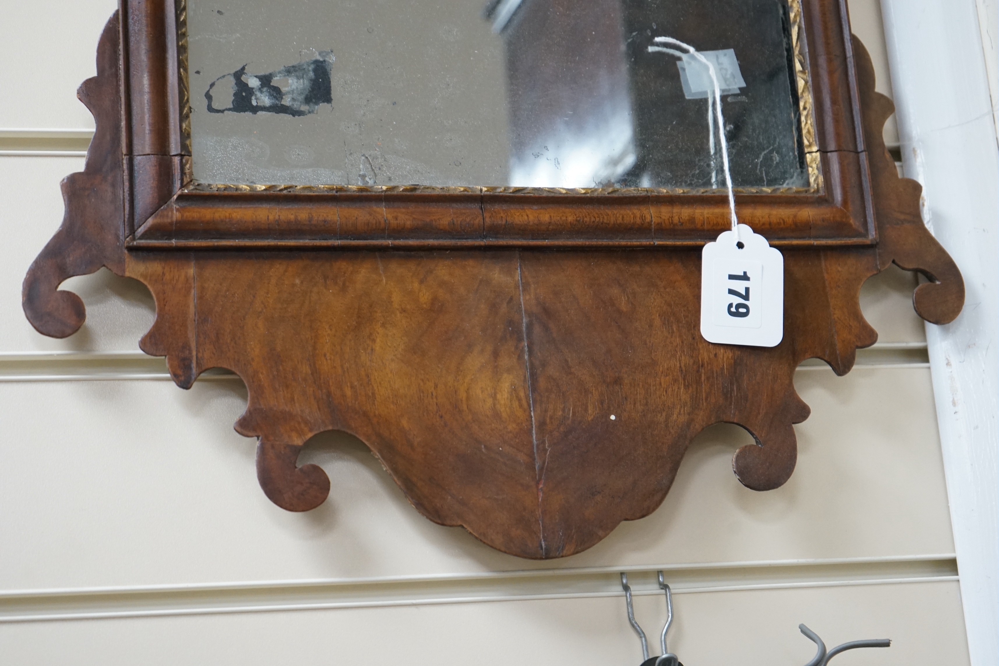 A George III style walnut and parcel gilt fret cut mirror, width 42cm, height 81cm